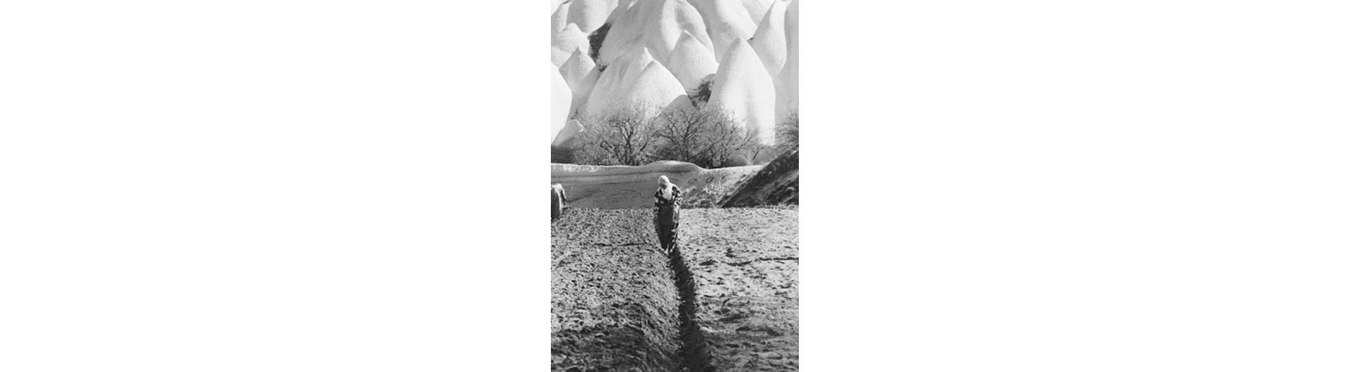 Black and white photo of hooded woman in a field by Barbara Sparks