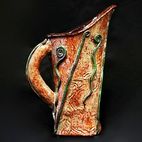 hand-made pitcher with green decorative elements