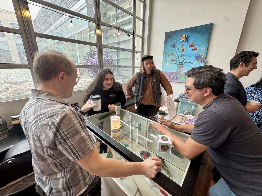 Members gather around a counter chatting over coffee