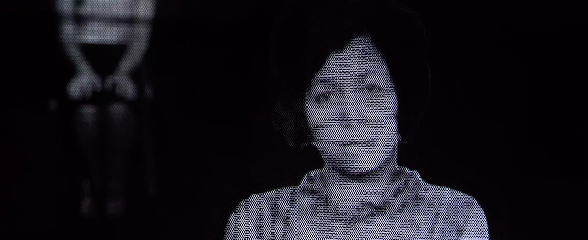 Disjointed black and white still of woman sitting looking at camera