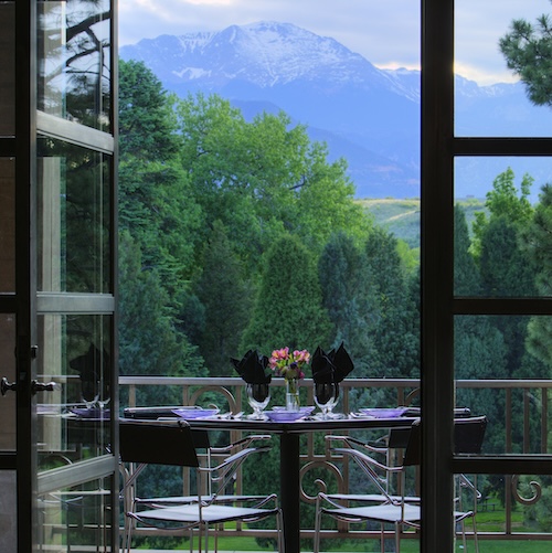 A table set on the balcony with a beautiful view of Pikes Peak