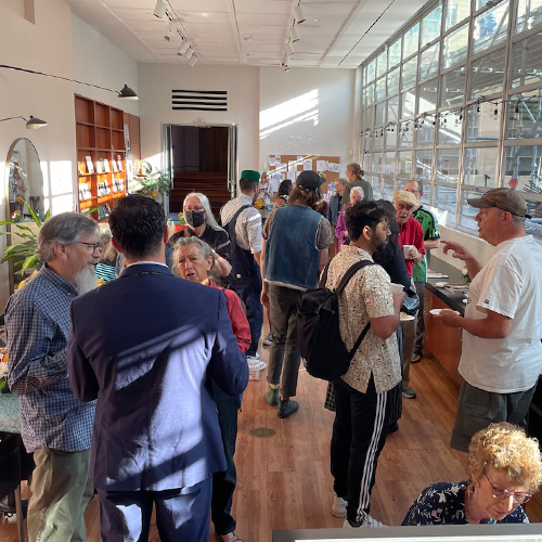 Museum members mingle while drinking coffee and eating snacks