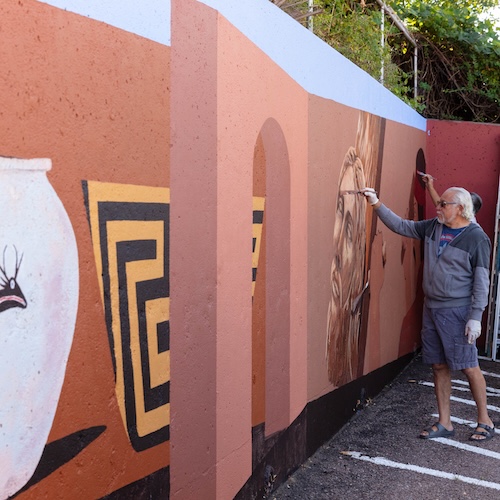 Colorado muralist Emanuel Martinez repainting Arte Mestiza at the Fine Arts Center parking lot
