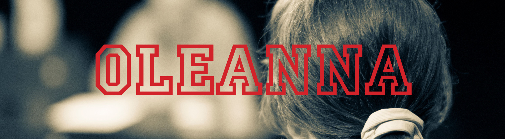 Sepia image of the back of a woman's head with the word "Oleanna" superimposed